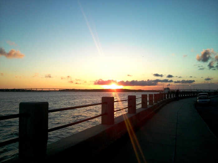 The sun glinting as it drops behind the Ashley River in Charleston, SC