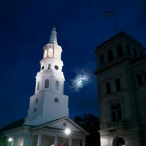 A full moon framed between St. Michaels Church and the US Post Office in Charleston, SC