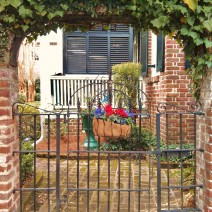 A very patriotic flower basket hanging on a beautiful Charleston gate.