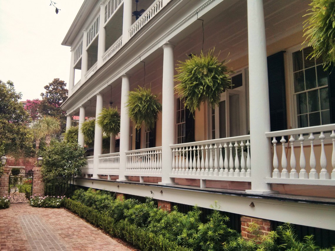 These "fern balls" adorn the piazza of a beautiful Charleston single house, which has beautiful iron gates as well.
