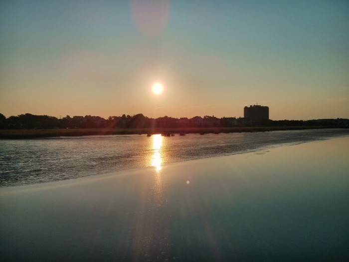 The sun rising over the peninsula of Charleston, SC is beautifully reflected in the pluff mud flats along the Ashley River.