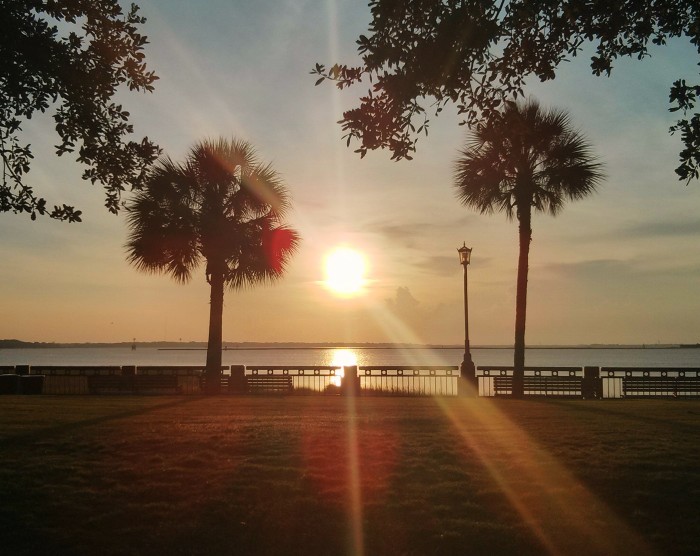The sun rising over Charleston Harbor as seen from Waterfront Park.