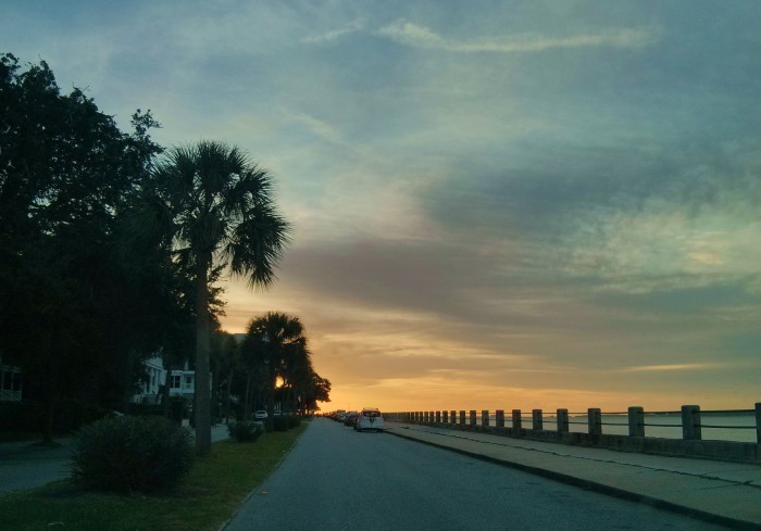 The sun rising in Charleston, SC lights up the sky along the Low Battery.