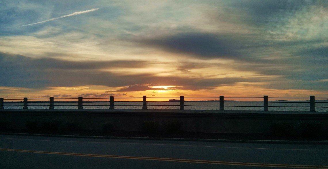 The sun rising above Charleston Harbor, Fort Sumter and the High Battery.