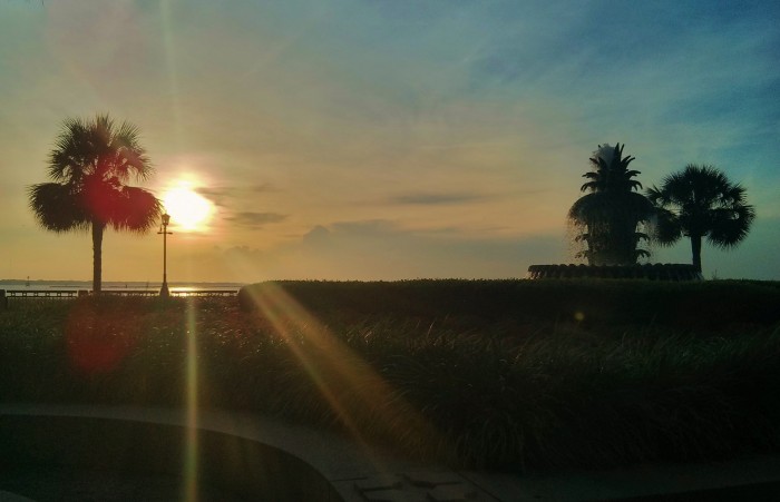 The sun rises above Charleston Harbor, illuminating Waterfront Park and its beautiful Pineapple Fountain.