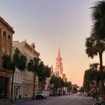 Early morning along Broad Street in downtown Charleston. The sun is lighting up the steeple of St. Michael's Church.