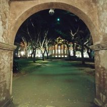 The Porters Lodge, built about 1850, framing a nighttime view of Randolph Hall (built 1829-30) and the Cistern at the College of Charleston.