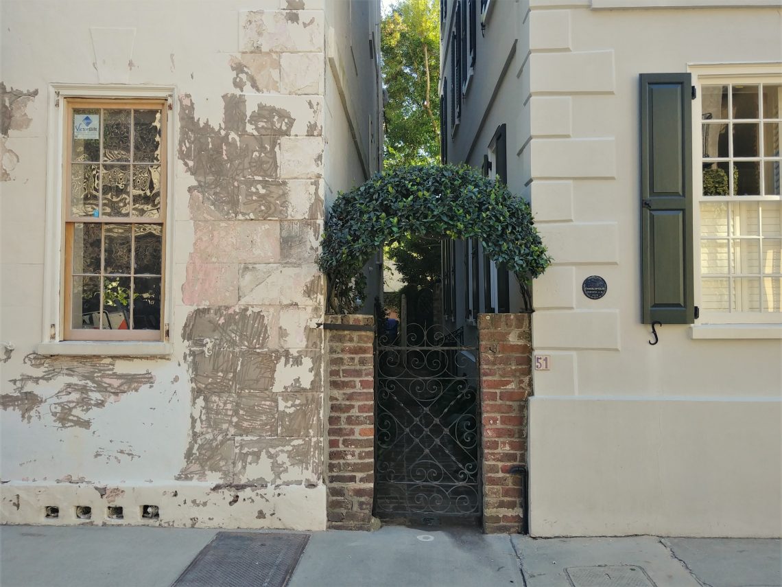 A cool little gate and its greenery cap on Tradd Street between the quoin covered corners of two houses. How Charleston.