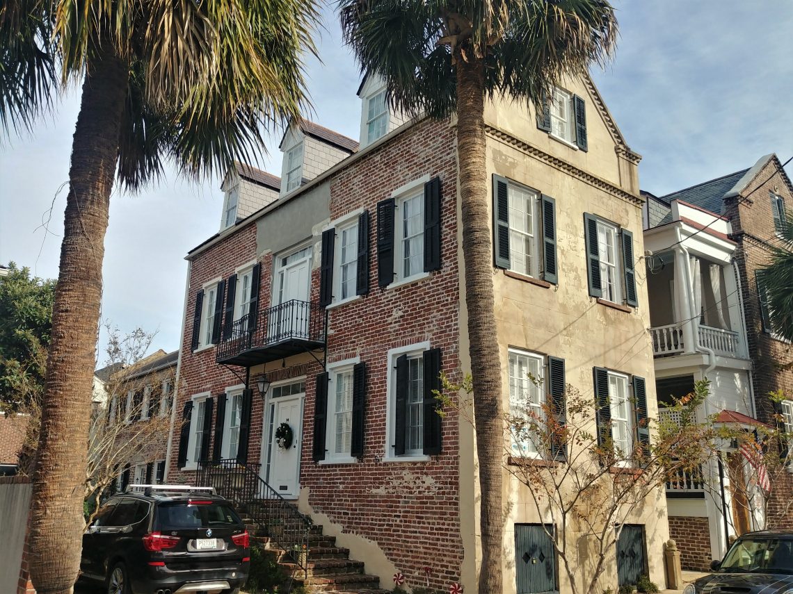 This handsome house on Queen Street, c 1850, once had a very different look. This was once a classic Charleston single house with a double piazza -- you can tell by the large doors that open on the first and second floors. 