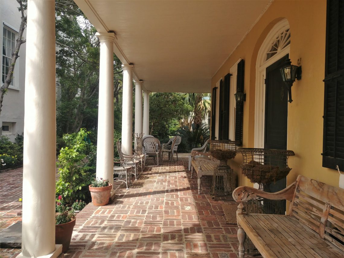 This cool seating area is under the house's piazza -- the side porch of a Charleston single house. A piazza is a type of porch, but not all porches are piazzas! You can find this one on South Battery.