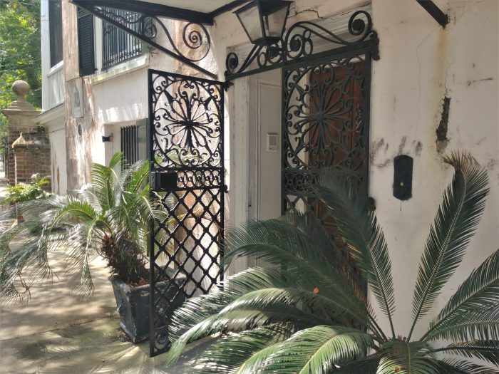 Unlike for other houses of its age with side piazzas (c. 1800),  this centrally located street front door is the main entrance to the house. After passing through its beautiful wrought iron gates, the door leads to a staircase that provides access to the main floor. You can find it on South Battery.