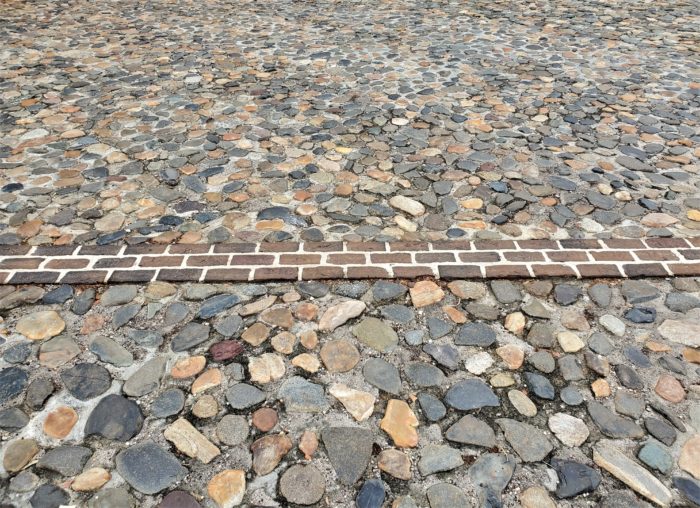 This line of bricks represents where the wall (more specifically, a "redan") of the original walled city of Charleston once was. It was identified during an archaeological dig by the "Walled City Task Force." You can find it along the top of South Adger's Wharf and through the adjacent parking lot. Pretty cool.