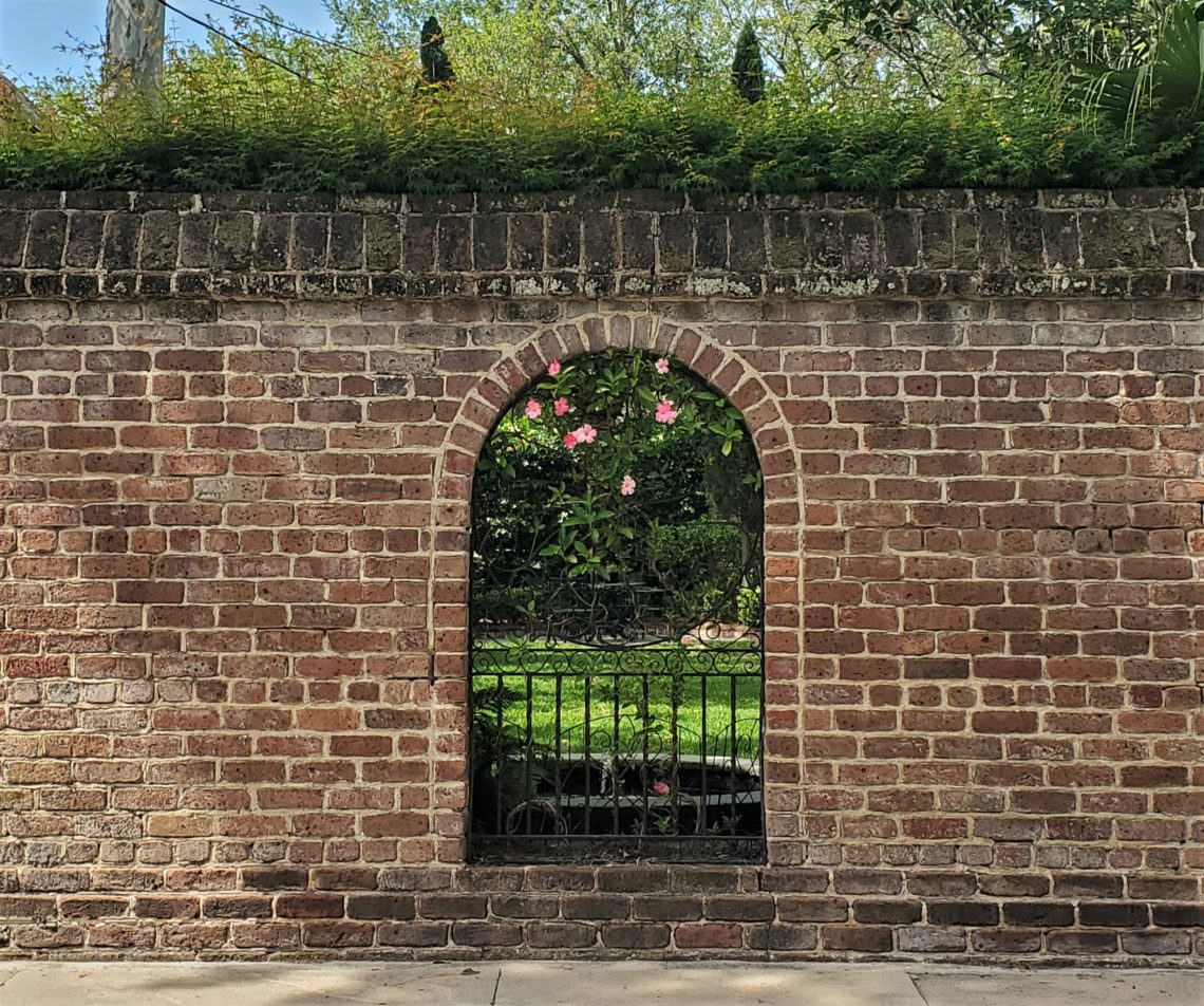 This cool wall with its window into the garden is on Lamboll Street. In the warmer weather it is always great to see the mandevilla flowering along the iron.